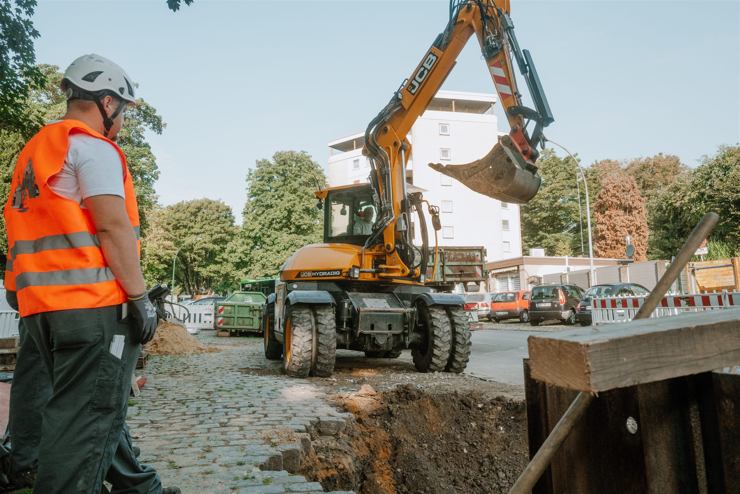 Mitarbeiter der Josef Koch GmbH überwacht Baggerarbeiten an einer Leitungsbaustelle